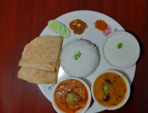 Balanced home-style Bangalore tiffin meal on a plate with rice, roti, dal, and vegetable curry.