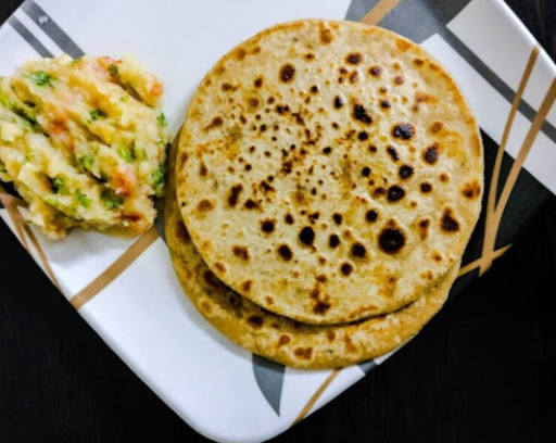 Two **home-style** **parathas** served with a side of mashed potato filling, common in **Bangalore tiffin services
