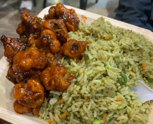 Rich platter featuring naan, pakoras, and several curries, indicative of quality food provided by **top tiffin services in Bangalore